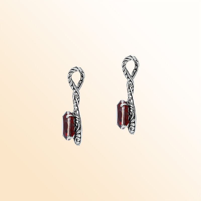 Handcrafted sterling silver twisted loop pendant featuring a round Red Garnet Quartz centerpiece with artistic engraving and expressive Balinese detailing.