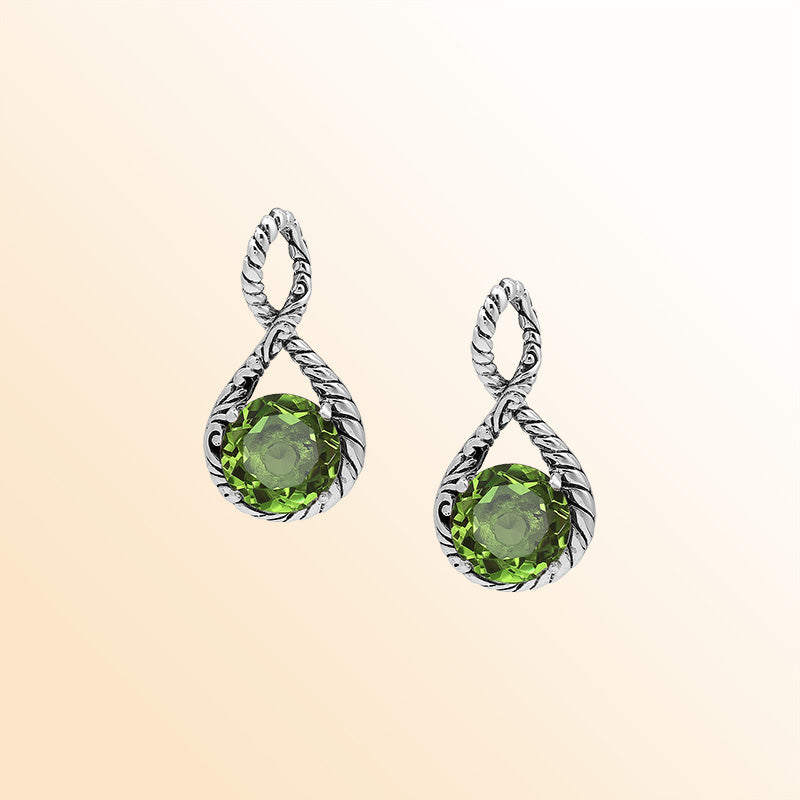 Handcrafted sterling silver twisted loop pendant showcasing a round Peridot Quartz stone with ornate Balinese engraving and polished artistic detailing.
