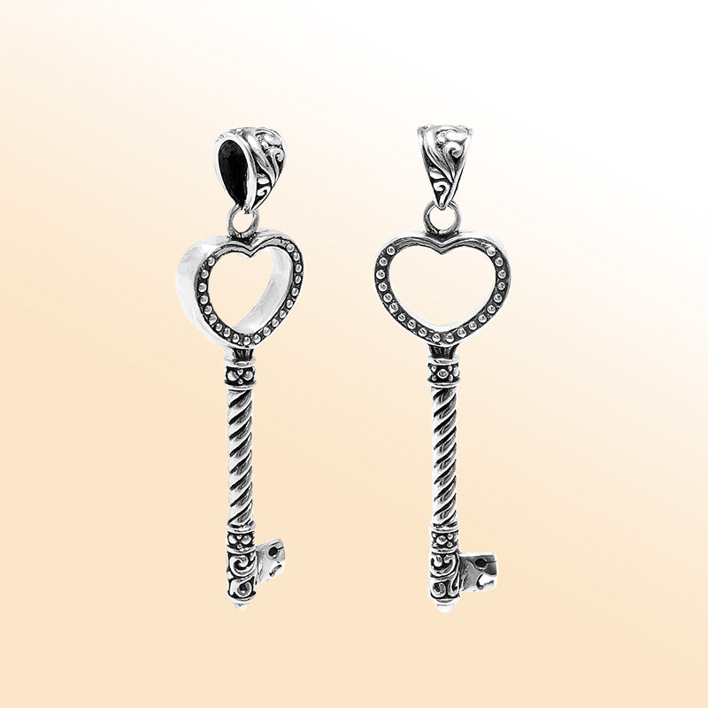 Artistic sterling silver heart-shaped key pendant with dotted textured accents, twisted stem, and polished finish designed for modern expressive jewelry wearers