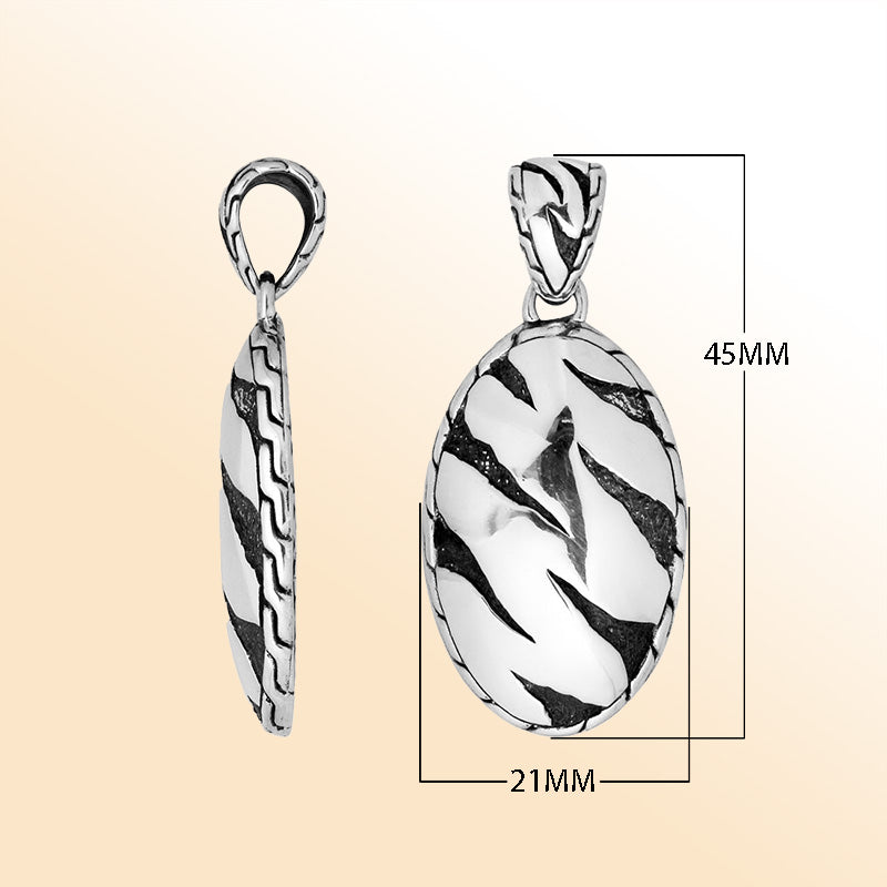 Artistic sterling silver oval pendant with abstract carved black design.