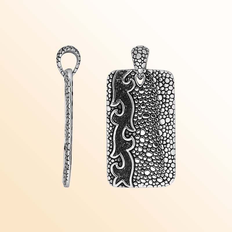 Artistic sterling silver rectangle pendant with pebble texture and carved accents.
