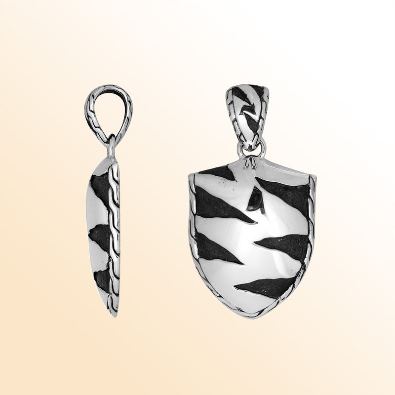 Artistic sterling silver shield pendant with oxidized wavy carved detailing.