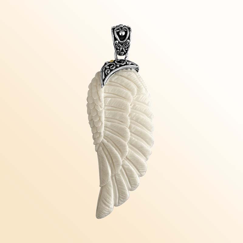 Artistic sterling silver wing pendant with hand-carved bone detailing.