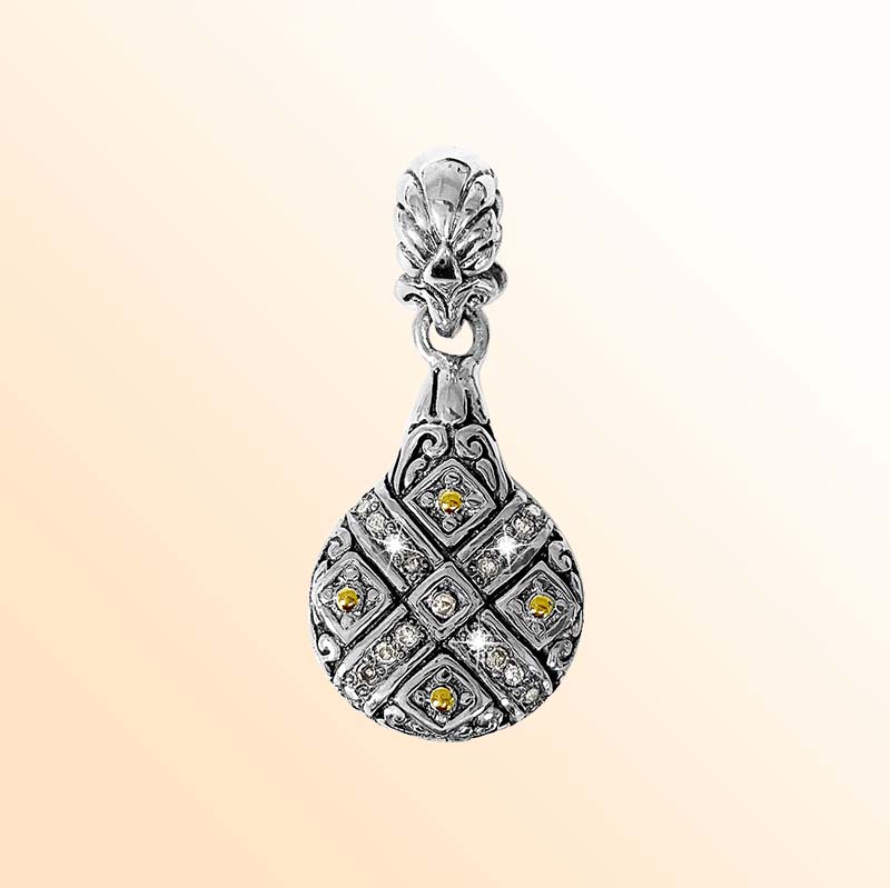 A handcrafted sterling silver and 18K gold drop-shaped pendant featuring diamond accents, ornate Balinese carvings, oxidized detailing, and expressive two-tone artistry for elegant everyday or occasion wear.