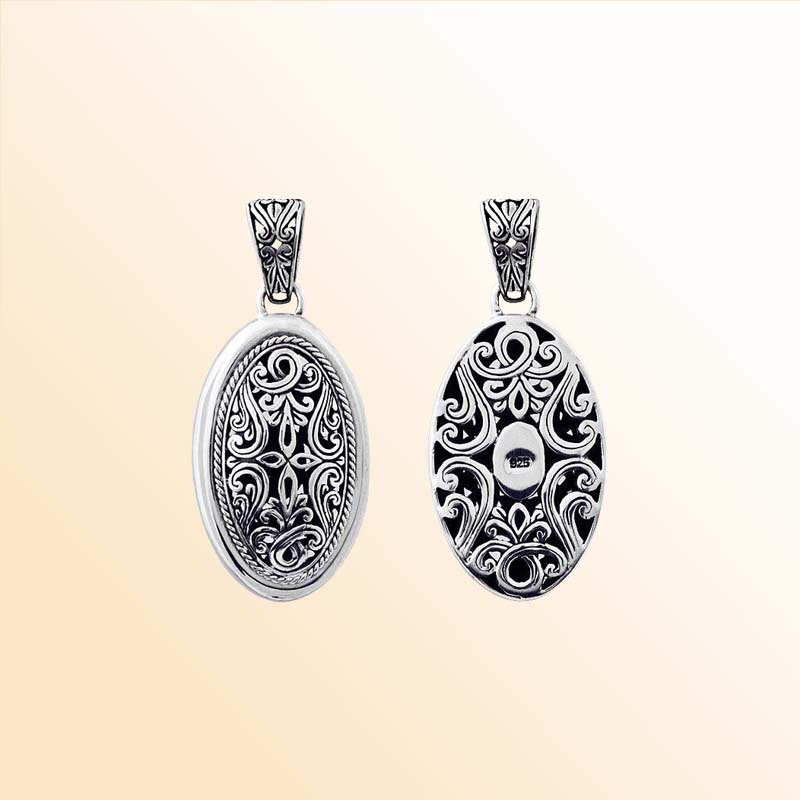 A handcrafted Silver Overlay Over Copper oval pendant featuring ornate Balinese filigree patterns, oxidized antique textures, and polished highlights ideal for expressive daily or special-occasion wear.