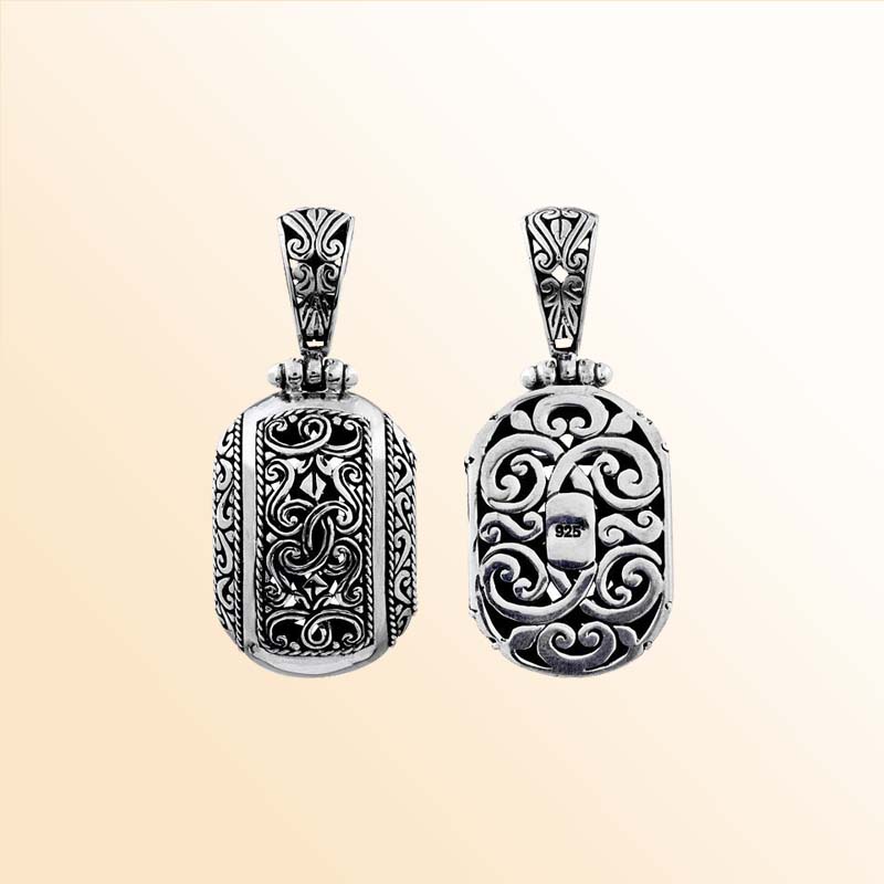 A handcrafted Silver Overlay Over Copper oval pendant showcasing ornate Balinese scrollwork, oxidized antique detailing, polished silver overlay, and traditional artistry ideal for expressive everyday or occasion wear.