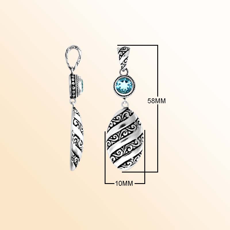 A handcrafted Silver Overlay Over Copper pendant featuring a vivid blue topaz quartz stone, artistic Balinese spiral carvings, oxidized textures, and polished detailing for elegant everyday or special-occasion wear.