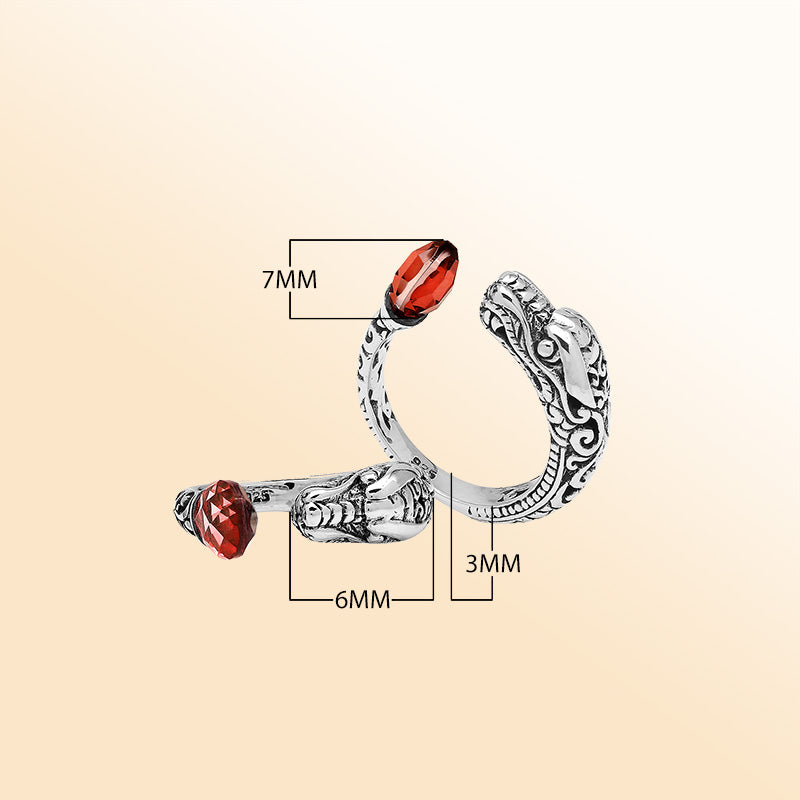 Handcrafted sterling silver dragon ring with two faceted Garnet Quartz, detailed Balinese carvings, and a bold bypass design.