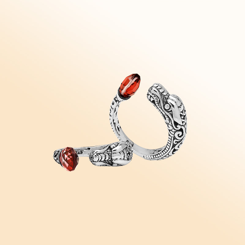 Handcrafted sterling silver dragon ring with two faceted Garnet Quartz, detailed Balinese carvings, and a bold bypass design.