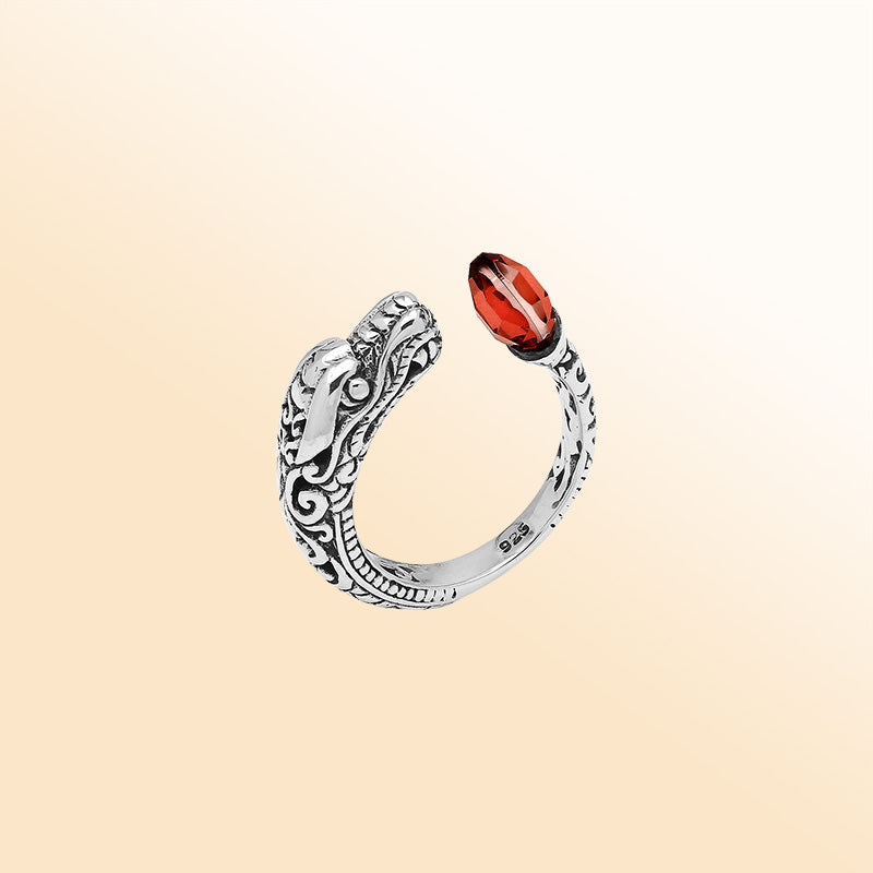 Handcrafted sterling silver dragon ring with two faceted Garnet Quartz, detailed Balinese carvings, and a bold bypass design.