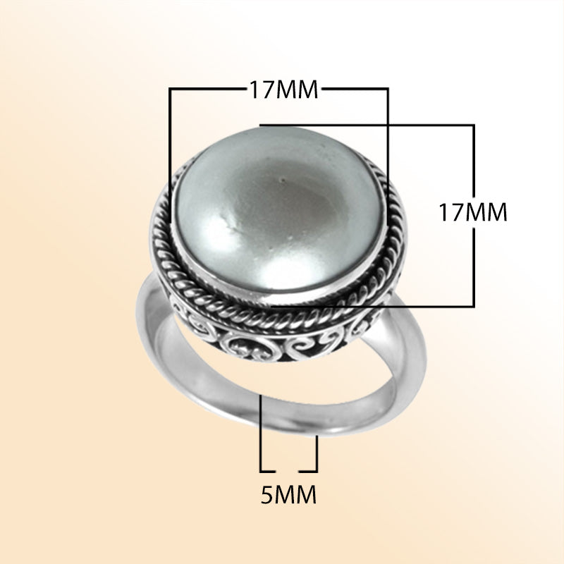 Sterling silver mother of pearl ring with polished cabochon stone, twisted rope bezel, and elegant Balinese scrollwork, handcrafted in Bali.