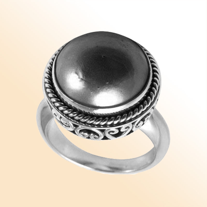 Sterling silver Grey Mabe Pearl ring with polished cabochon stone, twisted rope bezel, and artisan scrollwork, handcrafted in Bali.
