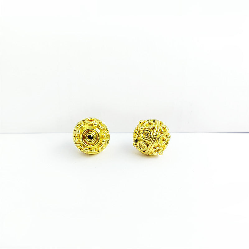 Round handcrafted India bead with 18K gold overlay over copper featuring decorative circular pattern.