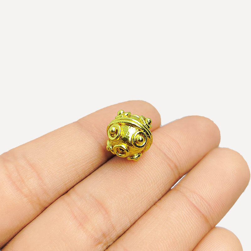 Handcrafted 18K gold overlay round copper bead from India with raised ornamental dot designs for jewelry making.
