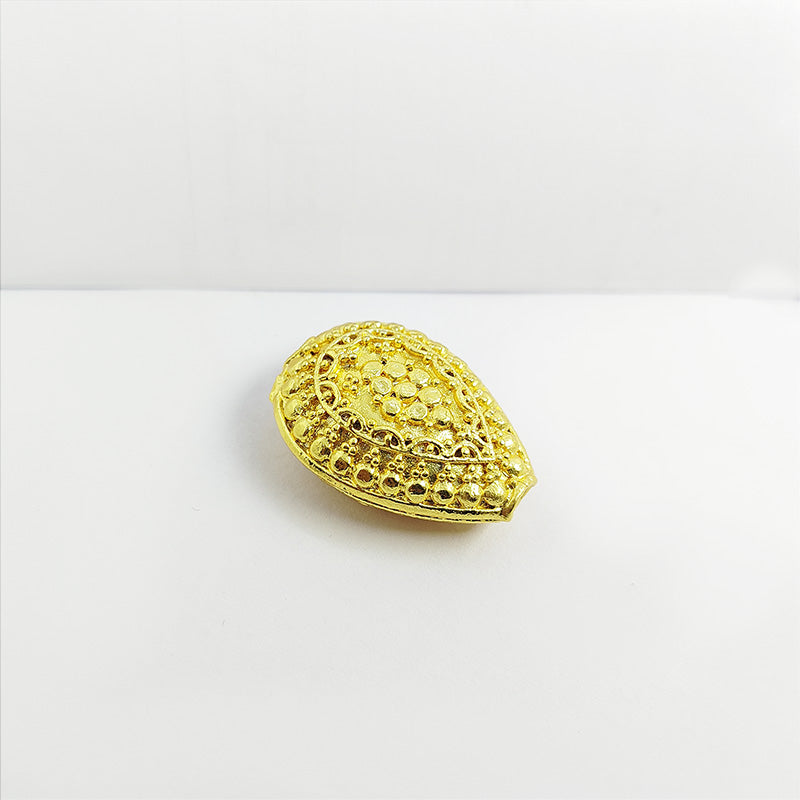 Handcrafted oval copper bead with 18K gold overlay from India featuring detailed dotted texture for jewelry making.