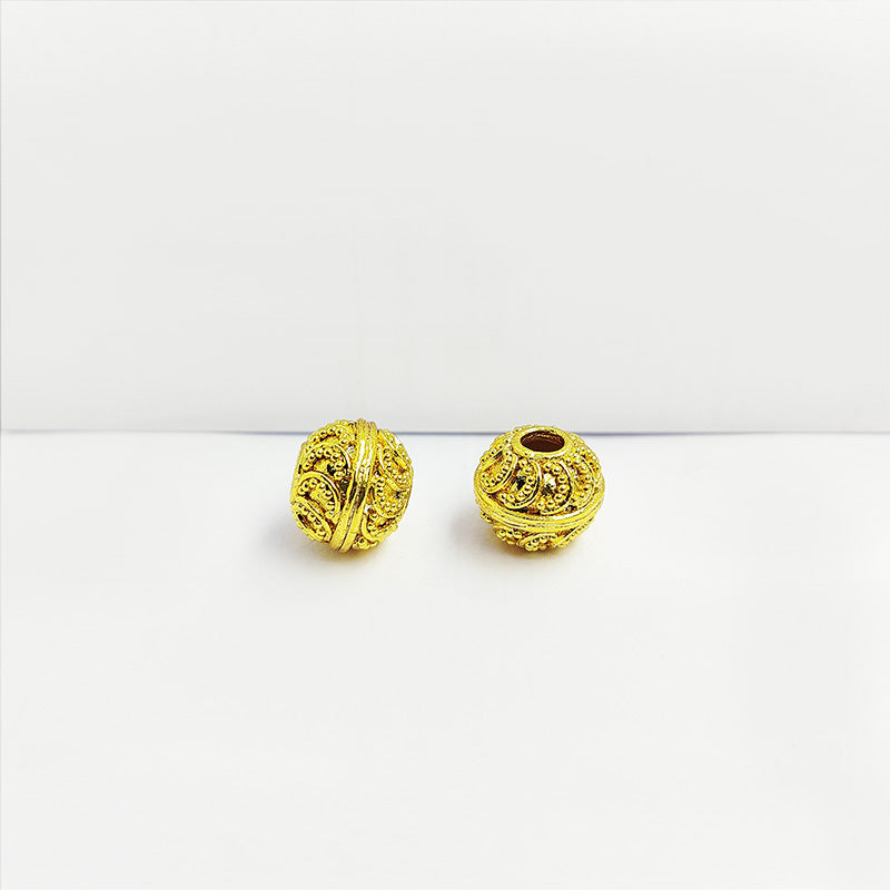 Handcrafted 18K gold overlay embossed copper round bead from India with swirl and dot patterns for jewelry making.