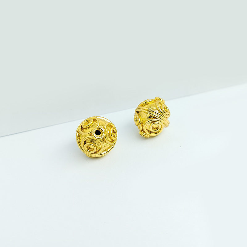 Handcrafted 18K gold overlay copper bead with swirl engravings from India for jewelry making.