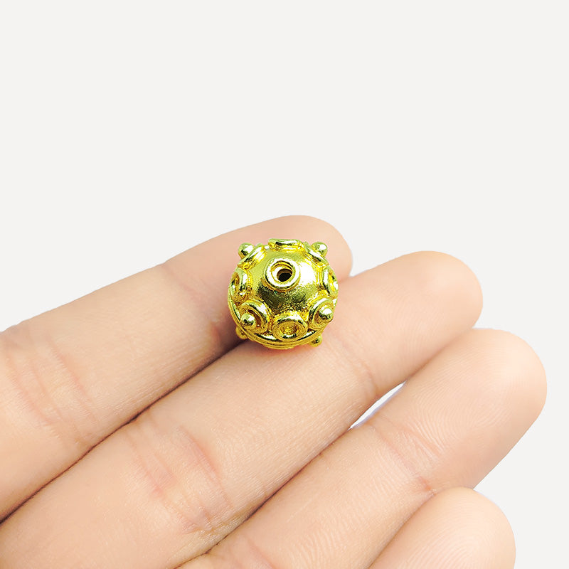 Handcrafted 18K gold overlay copper bead with embossed ring motifs from India for jewelry making.