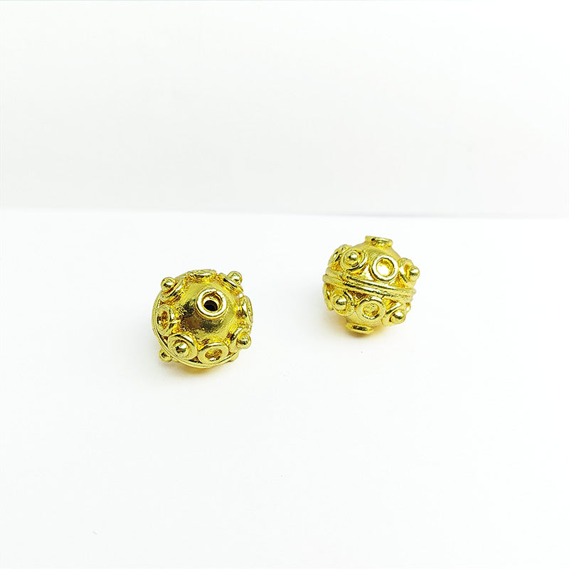 Handcrafted 18K gold overlay copper bead with embossed ring motifs from India for jewelry making.
