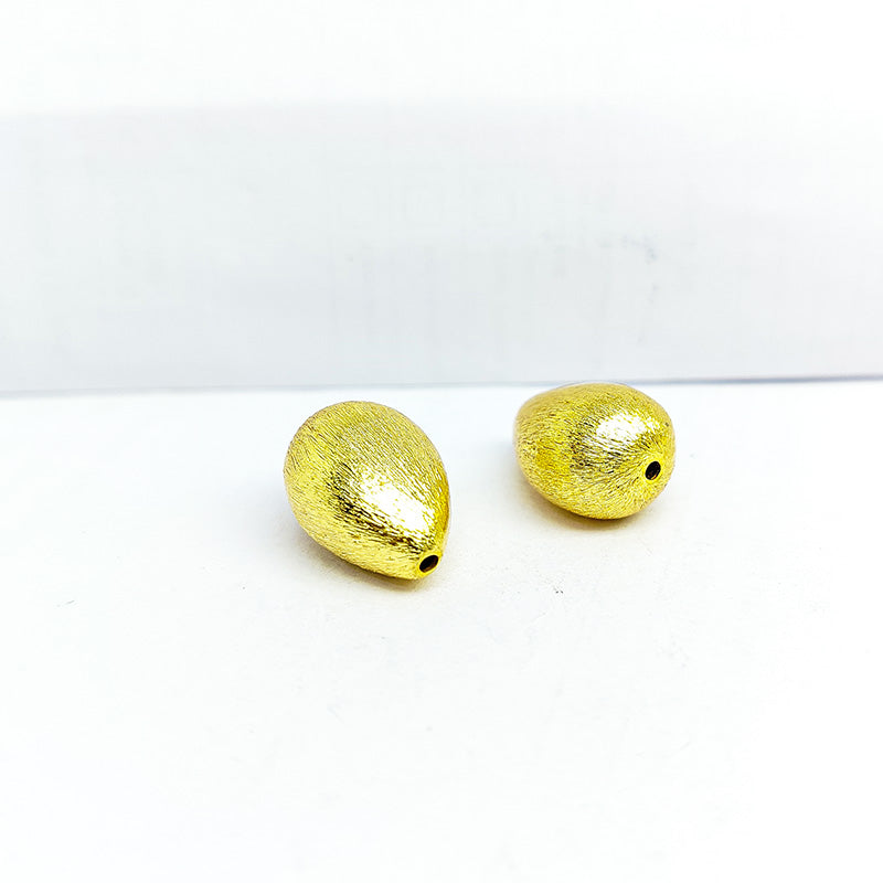 Handcrafted teardrop-shaped bead with 18K gold overlay over copper, made in India for jewelry making.