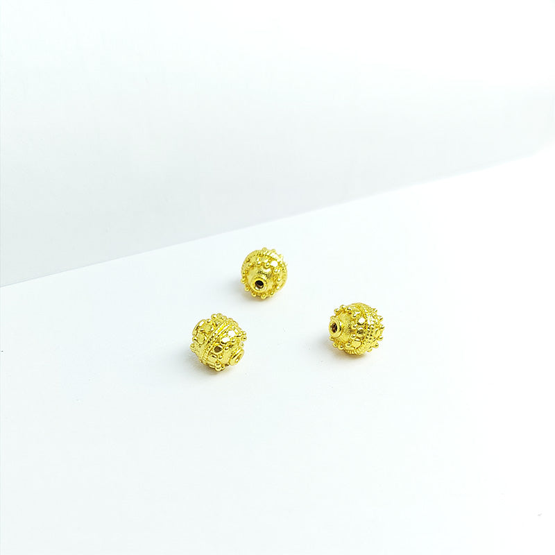 Ornate dotted round jewelry bead with 18K gold overlay over copper handcrafted in India