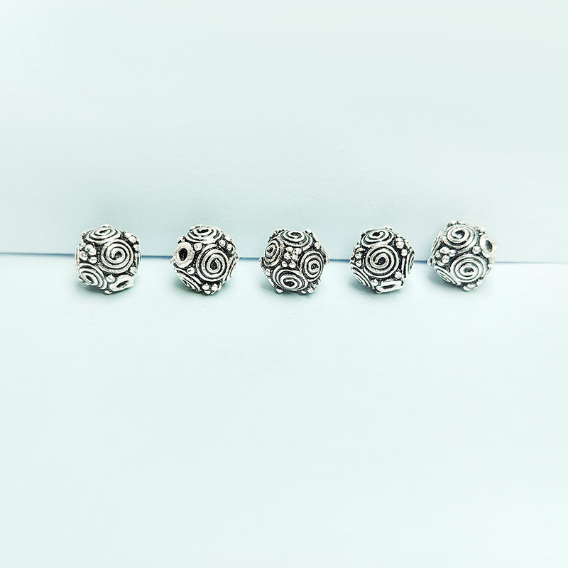 Silver spiral motif round copper bead handcrafted in India with antique finish and raised detailing