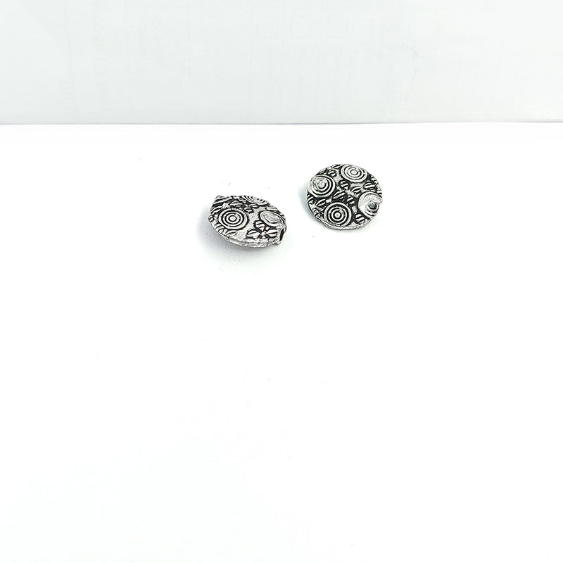 Single handcrafted silver and copper coin bead with detailed circle engraving for DIY jewelry design.