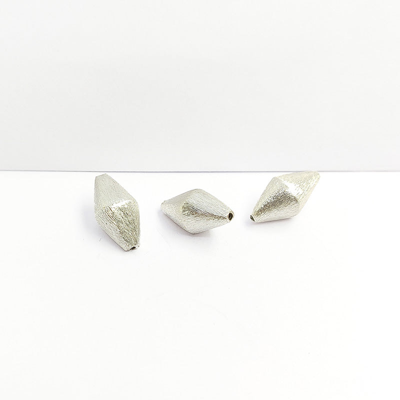 Sculptural silver and copper diamond shaped decor accent handcrafted in India with textured silver finish