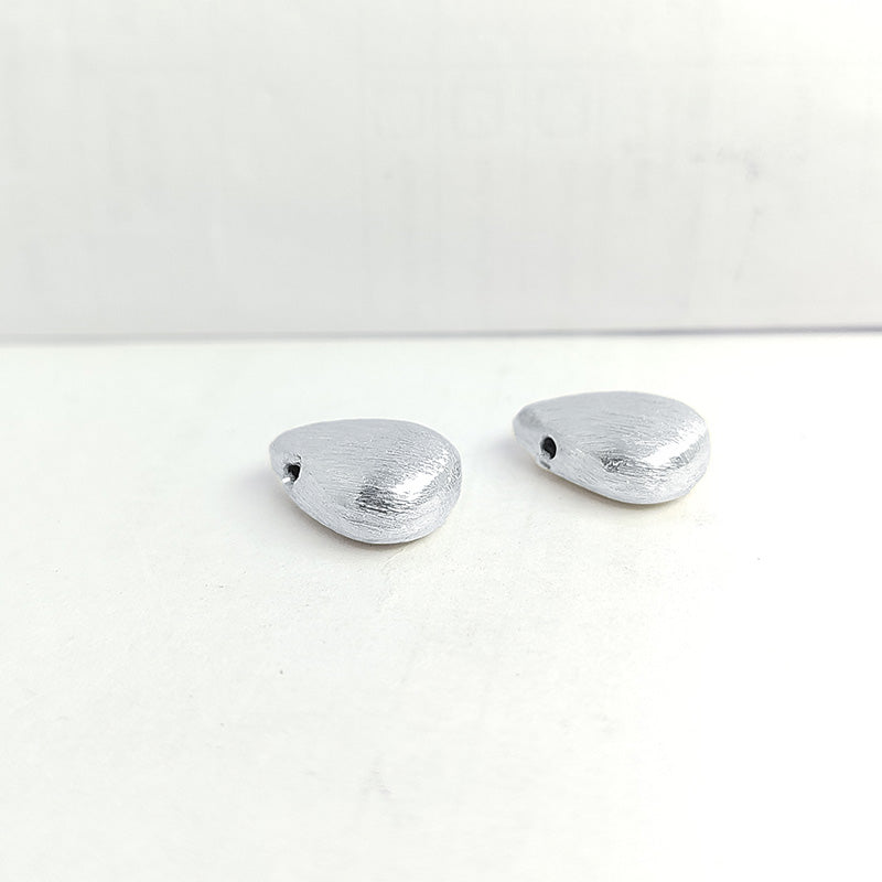 Delicate silver and copper teardrop bead accent handcrafted in India with textured silver finish
