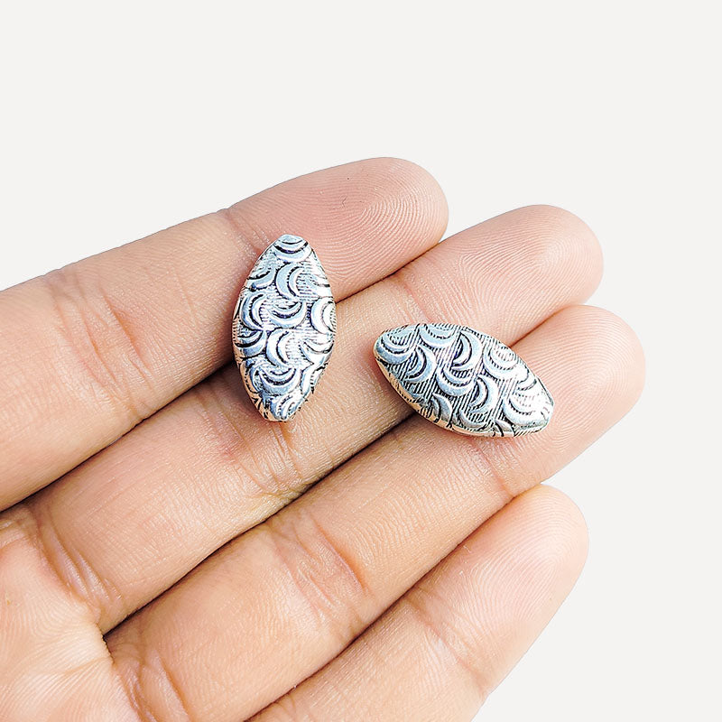 Silver leaf bead cap from India with textured curved design, handcrafted using silver overlay over copper.