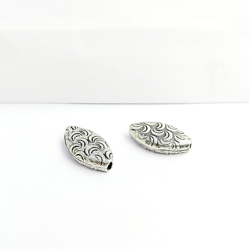 Silver leaf bead cap from India with textured curved design, handcrafted using silver overlay over copper.