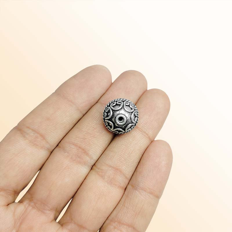 Ornate silver overlay over copper round bead handcrafted in India with scrollwork and rope design
