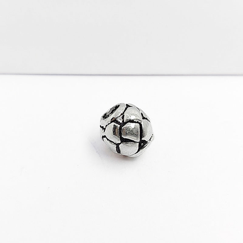 Geometric silver overlay over copper round bead handcrafted in India with hexagonal honeycomb texture
