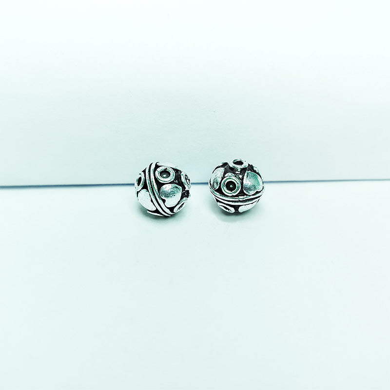 Studded silver overlay over copper round bead handcrafted in India with raised oval detailing