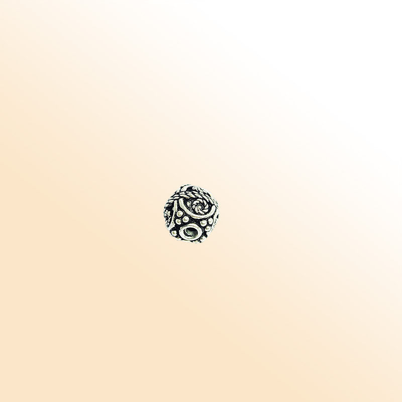 Artisan silver overlay over copper round bead with spiral scroll design, handcrafted in India for jewelry making.