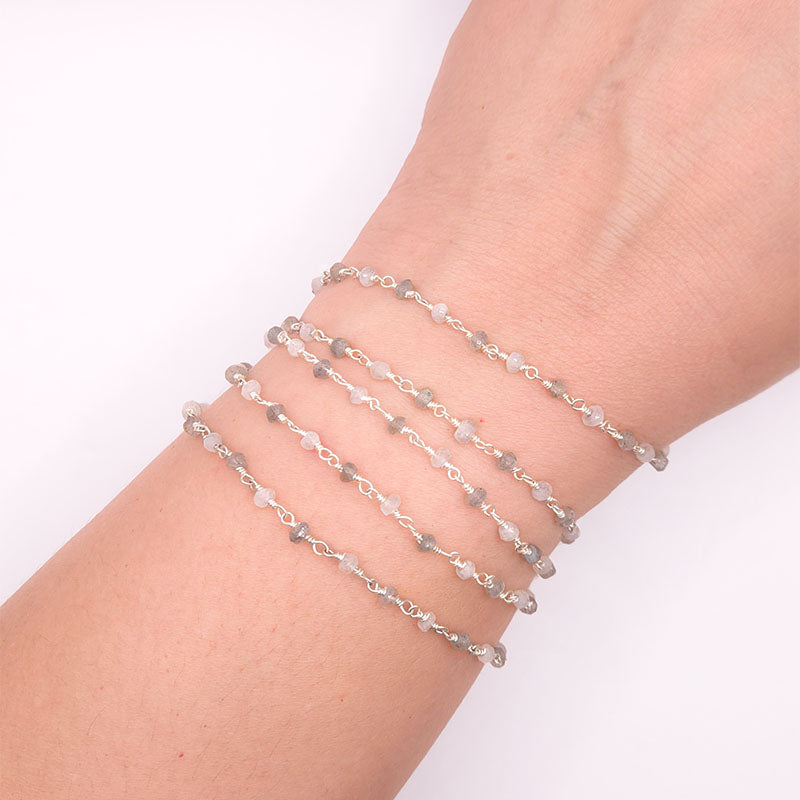 Silver overlay over copper rainbow moonstone and labradorite beading and extender chain with polished finish displayed on white background for retail jewelry use