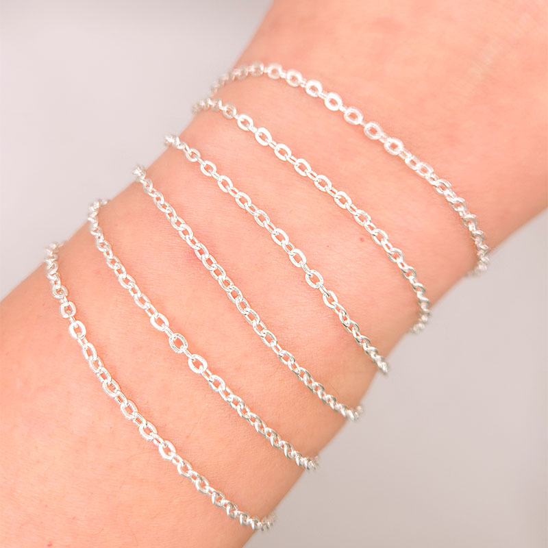 Silver overlay over copper beading and extender chain with polished oval links shown on white background for retail jewelry styling and customization