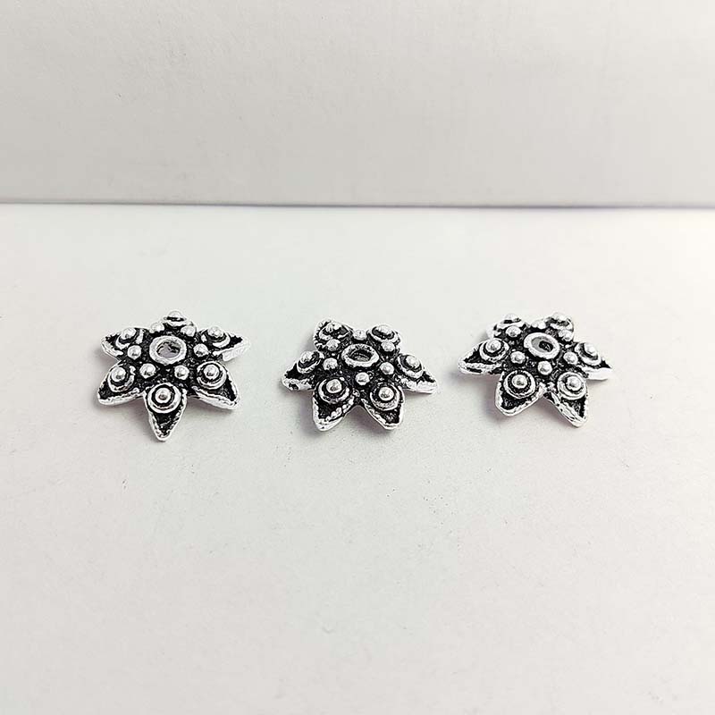 Silver overlay over copper bead cap from India handcrafted with floral design and oxidized silver finish
