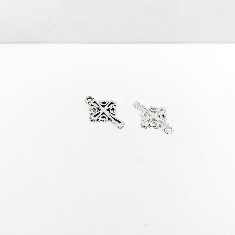 Polished silver overlay decorative cross pendant crafted from silver overlay over copper with scroll detailing in India.