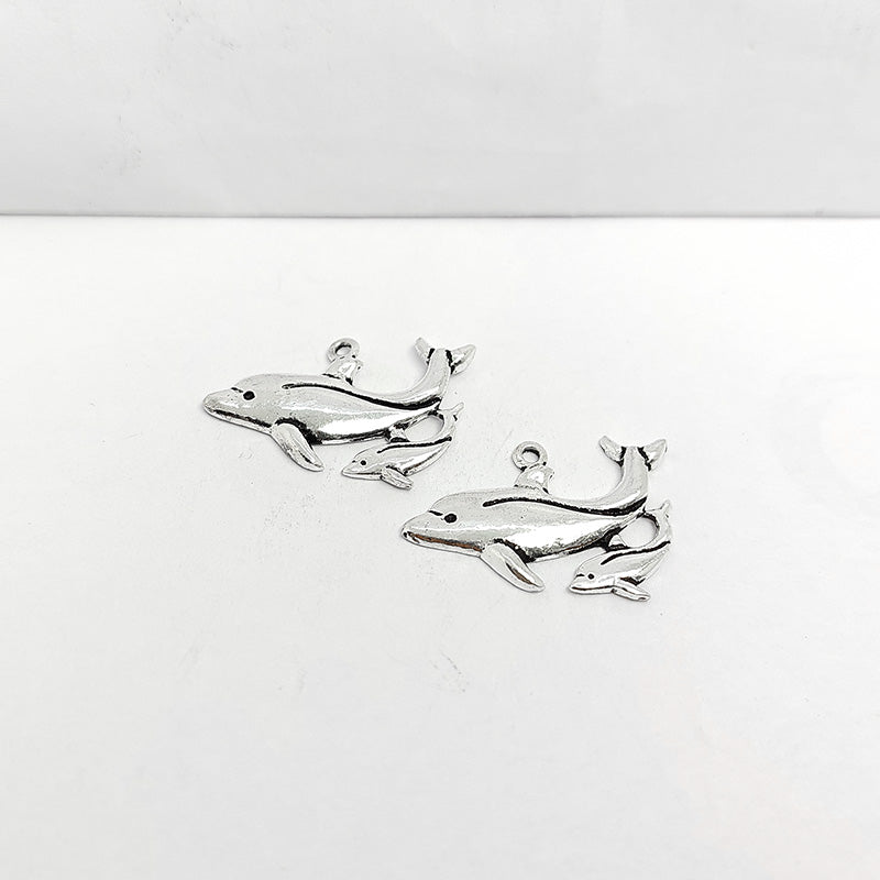 Polished silver overlay dolphin pendant crafted from silver overlay over copper featuring large and small dolphin design in India.