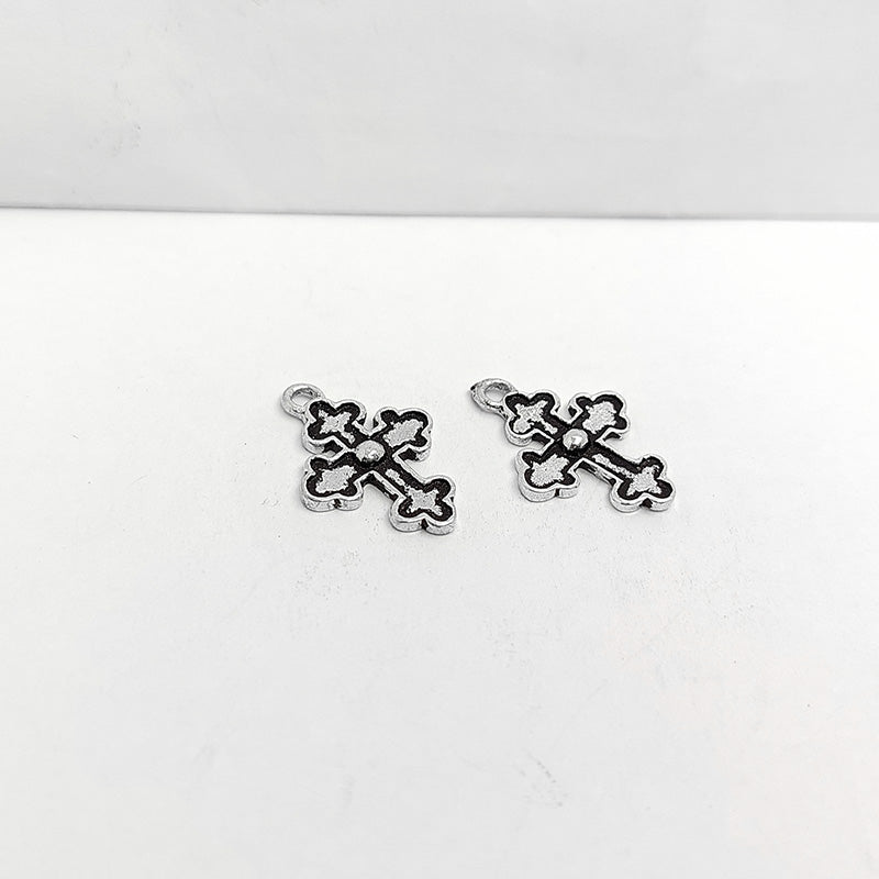 Polished silver overlay cross pendant with raised center detail crafted from silver overlay over copper in India.