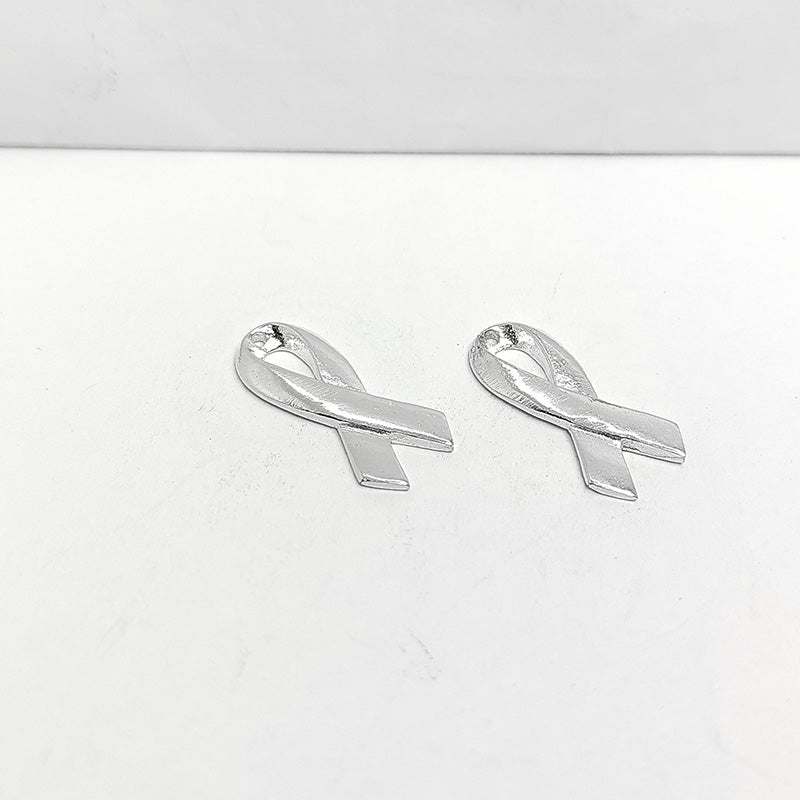 Polished silver overlay awareness ribbon pendant crafted from silver overlay over copper in India.