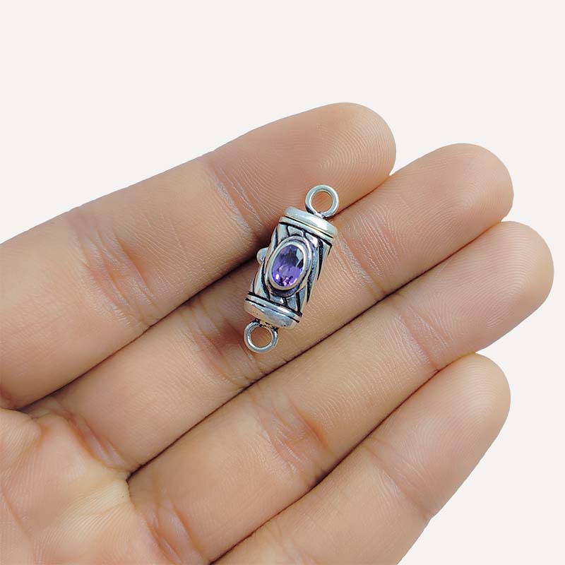 Polished silver overlay connector pendant with oval purple stone crafted from silver overlay over copper in India.