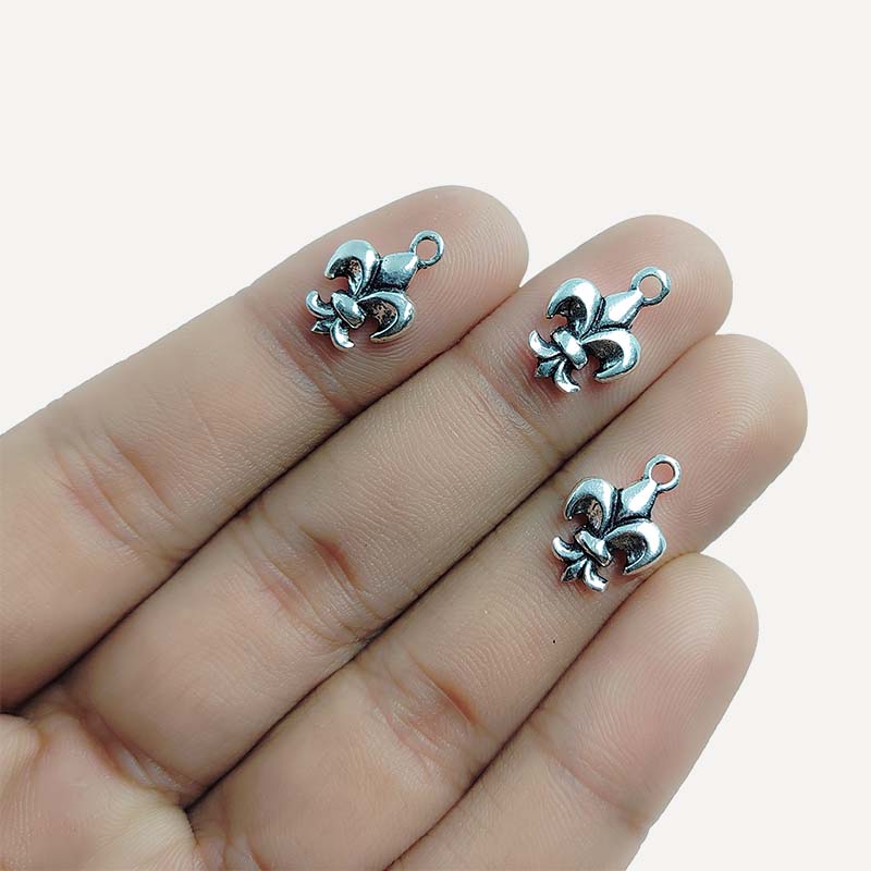 Handcrafted silver overlay over copper fleur-de-lis charm pendant from India with vintage-style detailing