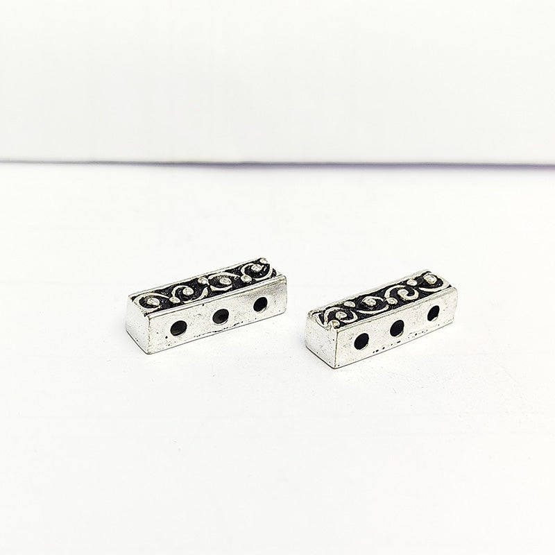Handcrafted silver overlay over copper spacer bar with three holes and swirl pattern from India for jewelry making