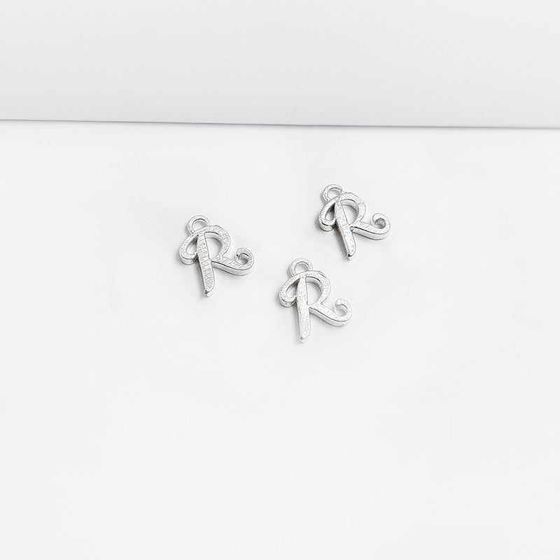 Handcrafted Silver Overlay Over Copper alphabet “R” charm from India with polished textured finish for handmade jewelry.