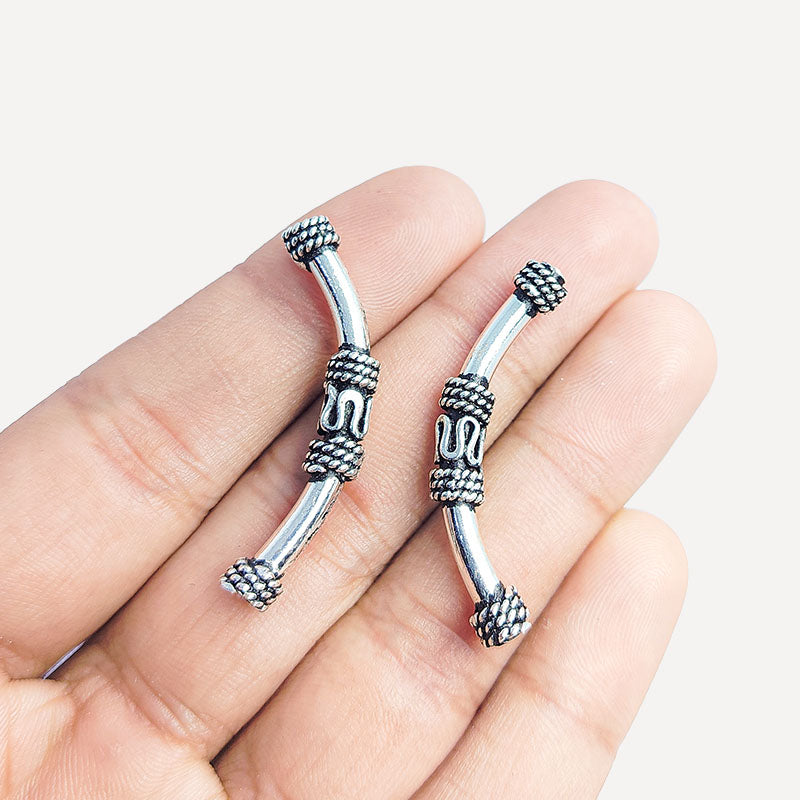 Decorative silver overlay tube bead over copper with curved shape and oxidized finish handcrafted in India for jewelry making