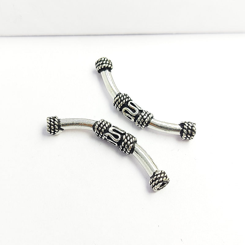 Decorative silver overlay tube bead over copper with curved shape and oxidized finish handcrafted in India for jewelry making