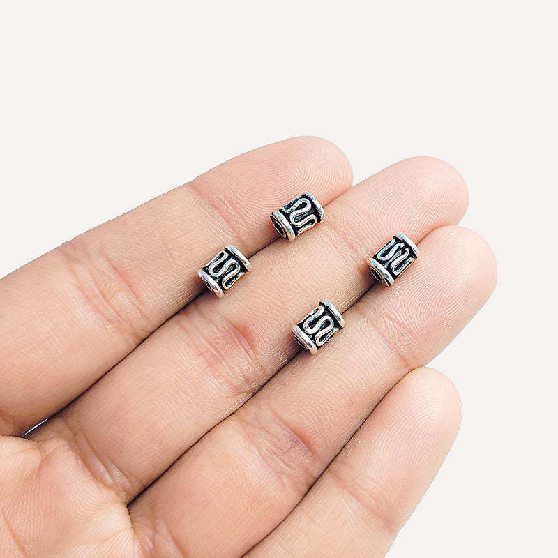 Decorative silver overlay tube bead over copper with openwork pattern and oxidized finish handcrafted in India for jewelry making