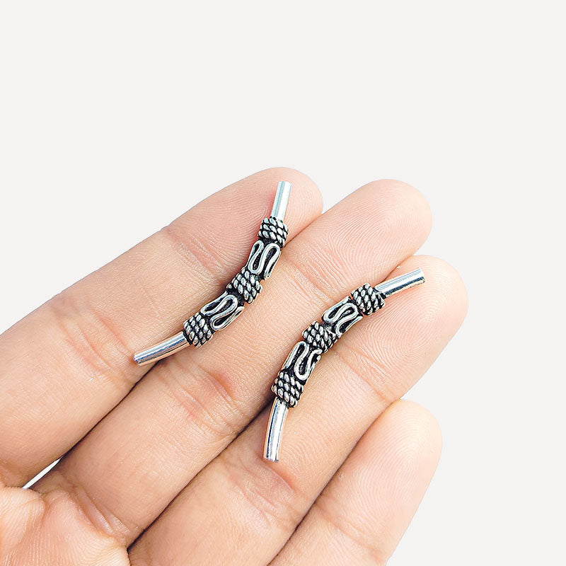 Handcrafted silver overlay over copper tube Bali charm from India with oxidized detailing and curved tube design